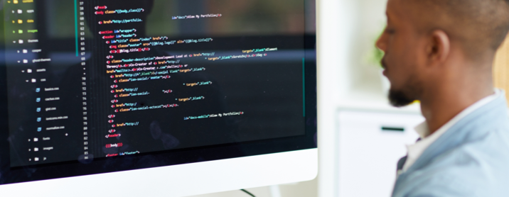 Young Black man working on a coding project on his computer