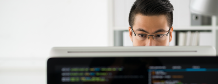 Developer sitting at his computer working on a coding project