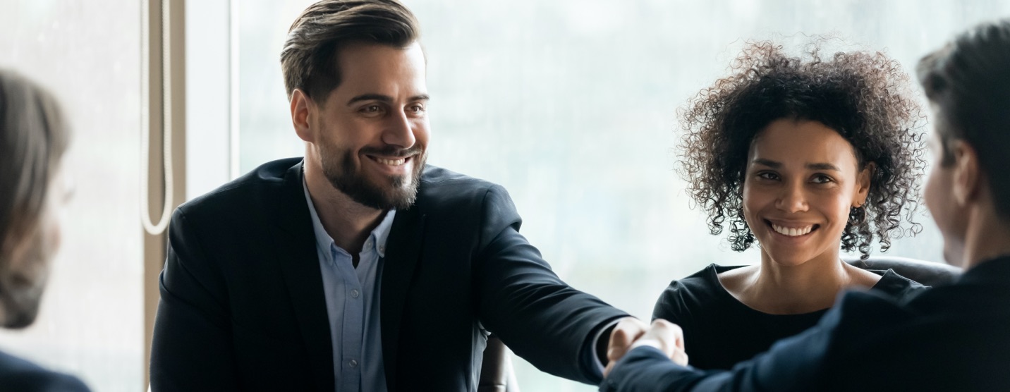 Happy business people shaking hands after sealing a deal