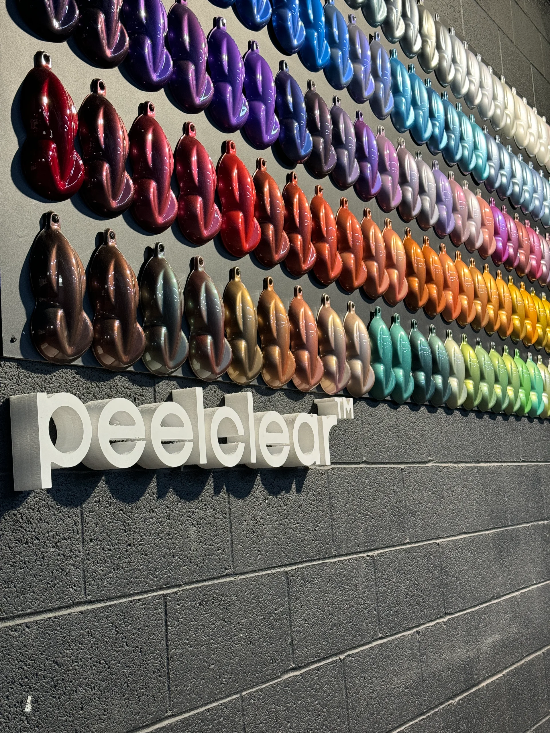 Mur de couleurs avec le logo Peelclear en dessous, dans notre usine principale.