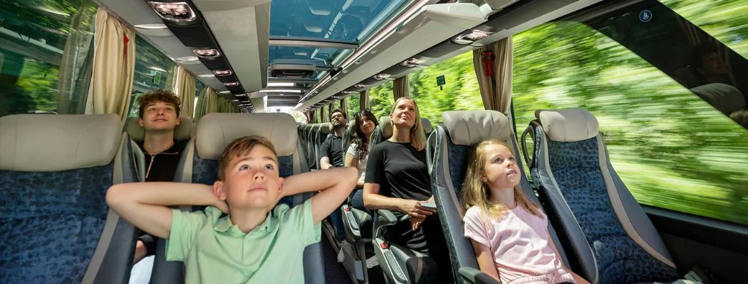 Passengers Enjoying Watching TV while Riding in a Bus | Phoenix Charter Bus Services