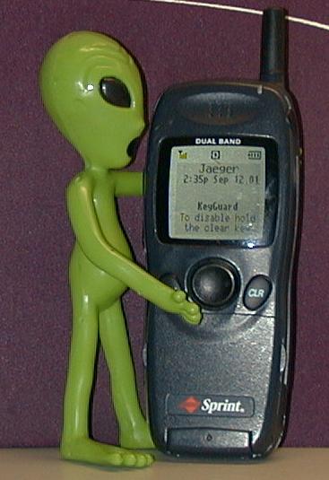 little green alien with wireless phone