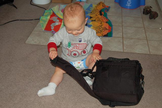 Calvin sports training pants while playing with daddy's camera bag