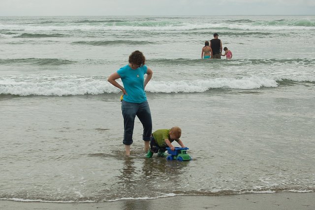 Calvin and Kiesa push a dump truck through the Pacific Ocean