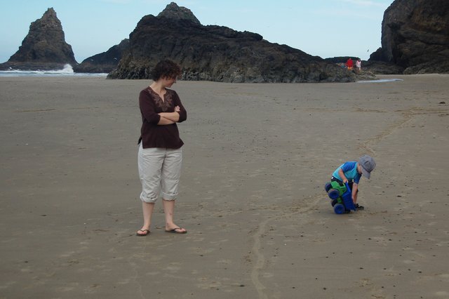 Kiesa watches Calvin dump his dump truck on Agate Beach