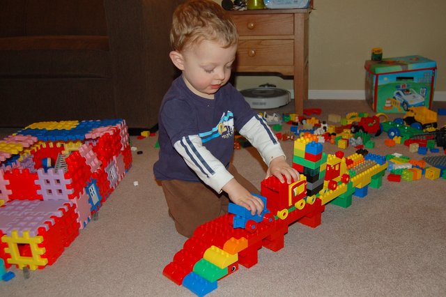 Calvin pushes a Duplo train over a viaduct