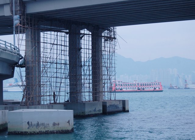 Bamboo scaffolding under an expressway suspended over Victoria Harbour