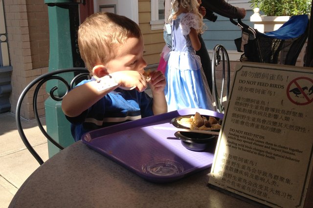 Calvin eats a Mickey Mouse waffle at Hong Kong Disneyland