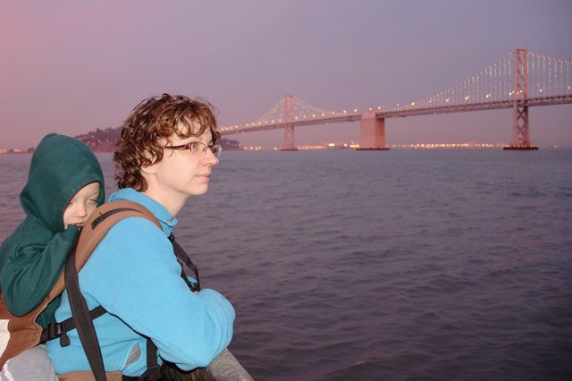 Kiesa and Calvin look out at the western span of the Bay Bridge at dusk