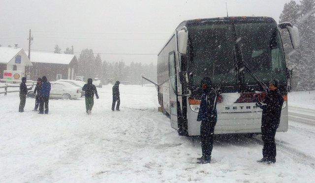 Bus puts on chains in the snow on CO 119 near Black Hawk