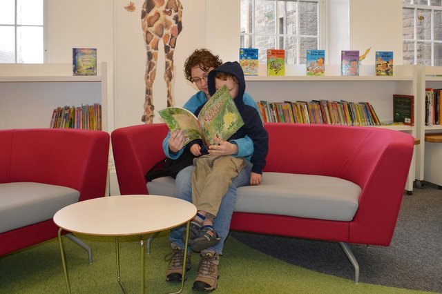 Kiesa reads to Calvin in the Edinburgh children's library