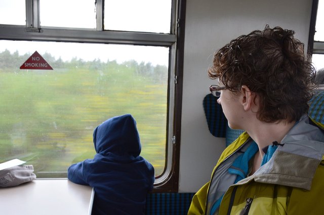 Calvin and Kiesa look out the window of the Strathspey Steam Railway at the Scottish countryside