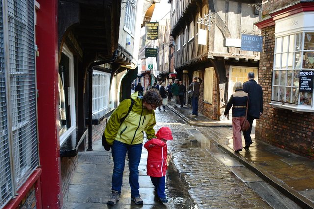 Kiesa tries to restrain Calvin from splashing in a puddle in York Shambles