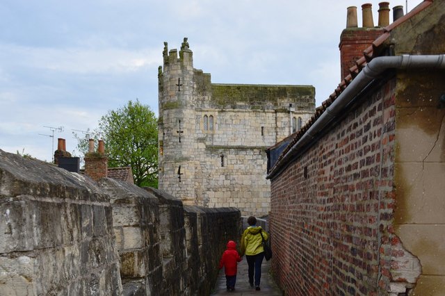 Calvin and Kiesa walk along the York city walls to Monk Bar