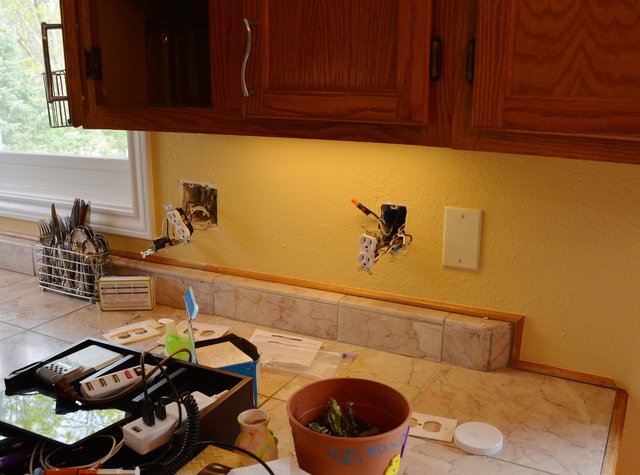 Electrical rewiring in process on kitchen counter