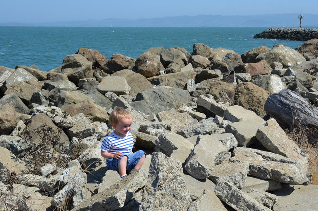 Julian sits on the seawall on Treasure Island