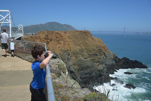 Calvin looks through binoculars at Point Bonita Lighthouse