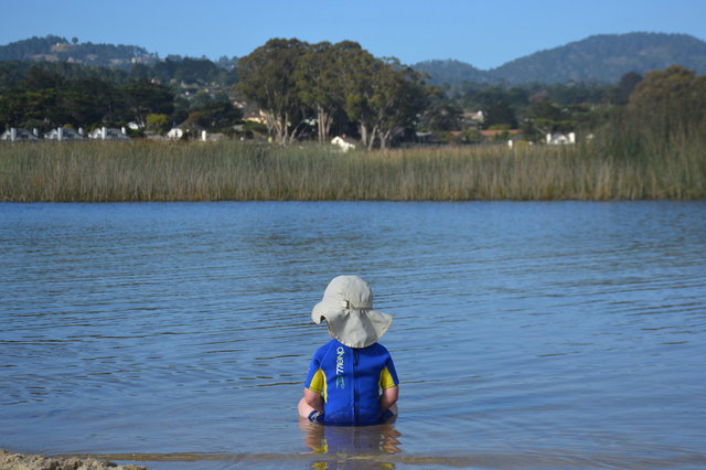 Julian sits in the lagoon at Carmel River State Beach