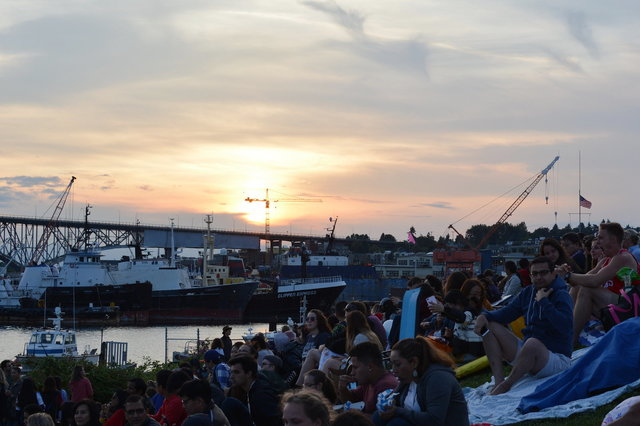 Sun sets over the Aurora Bridge while people wait for fireworks at Gasworks Park