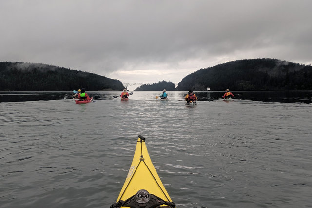 Kayakers paddle towards Deception Pass
