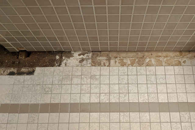 Tile removed, exposing extent of water damage
