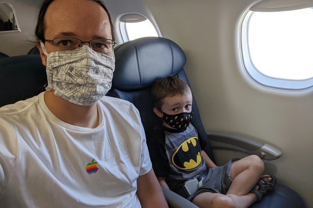 Jaeger and Julian wearing masks on a plane