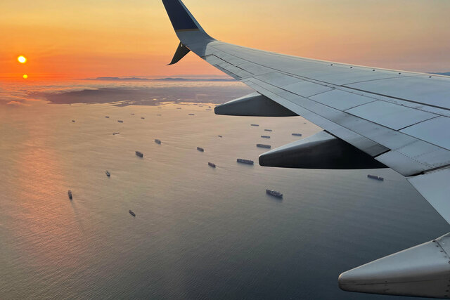 737 wing flying over the Port of Long Beach at sunset