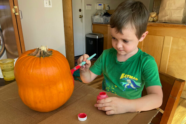 Julian paints a pumpkin for Halloween