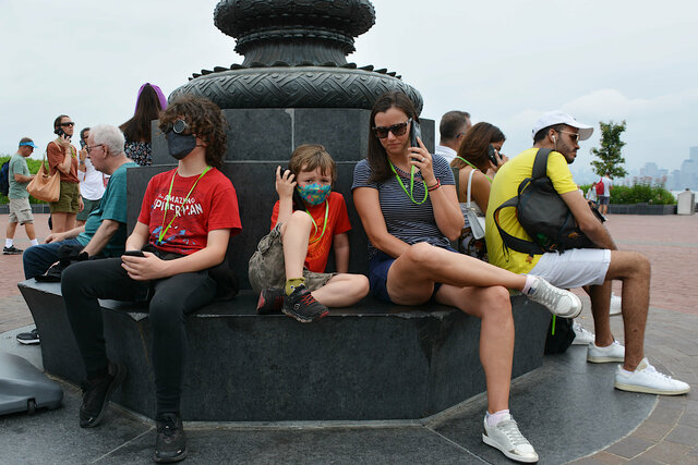 Calvin, Julian, and Aunt Bethany listen to the audio tour on Liberty Island