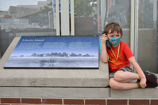 Julian listens to the audio tour on Liberty Island