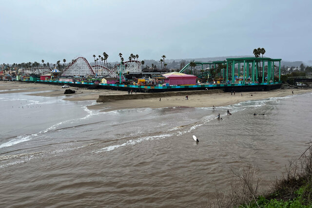 Surfers in the San Lorenzo River at the Beach Boardwalk