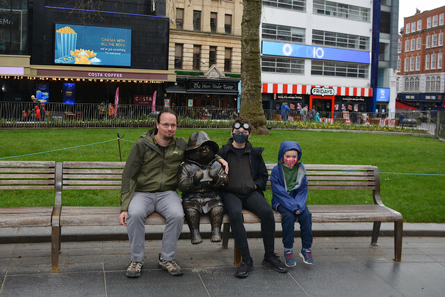 Jaeger, Calvin, and Julian with a statue of Paddington Bear in Leicester Square