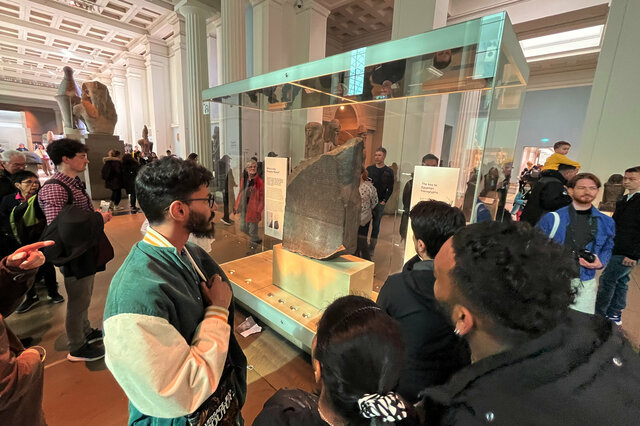 Visitors look at the Rosetta Stone