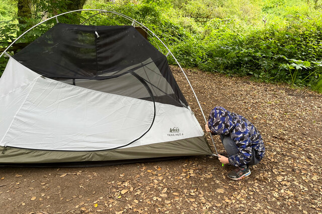 Julian helps pull the tent stakes