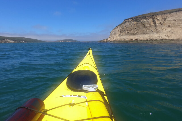 Kayak approaching the cliffs at the mouth of Drakes Estero