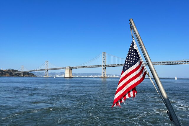 Flag on the back of ferry with the Bay Bridge