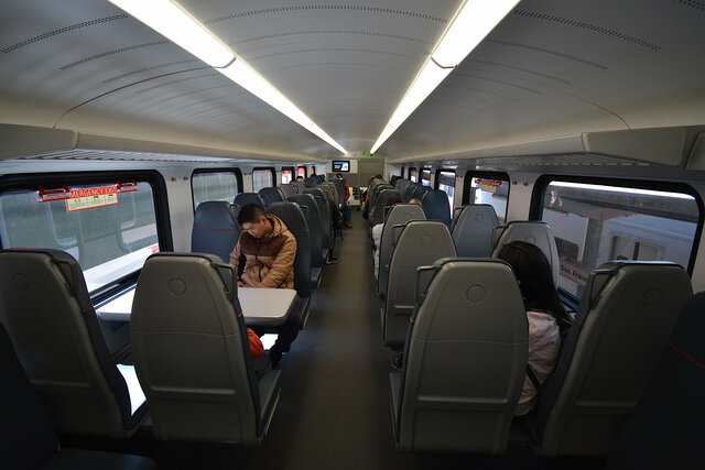 People sit in the upper level of the Caltrain Stadler KISS EMU