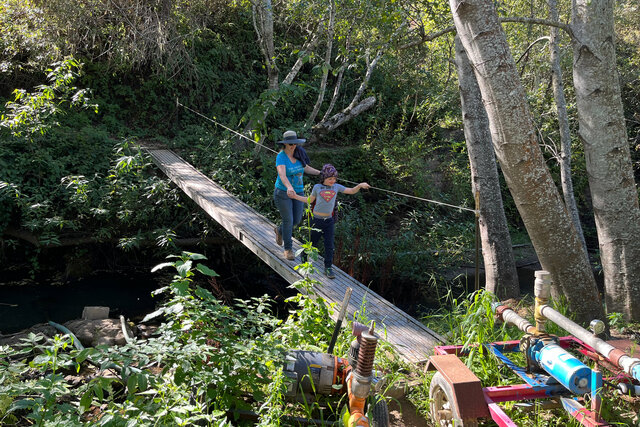 Kiesa and Julian cross a shaky footbridge