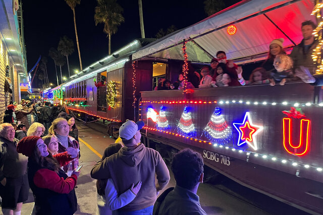 Holiday lights train pulls up to the boardwalk