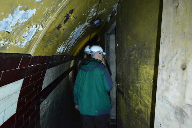 Walking along the hallway squeezed into the tube station corridor