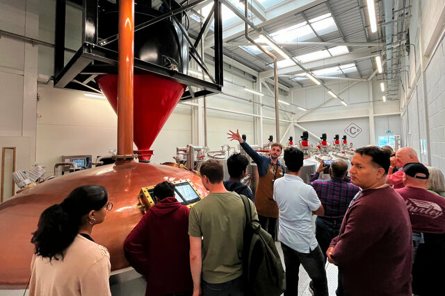 Tour guide points out the brewing equipment at the Clydeside Distillery