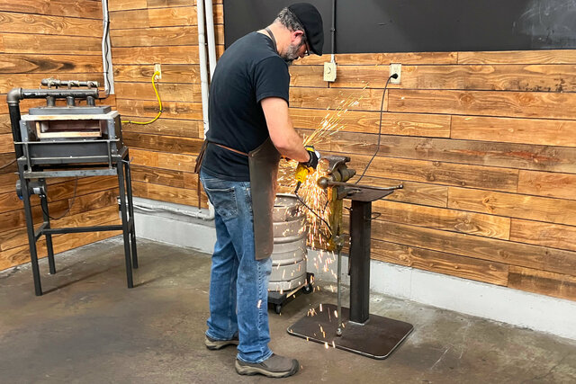 Blacksmith teacher grinds knives