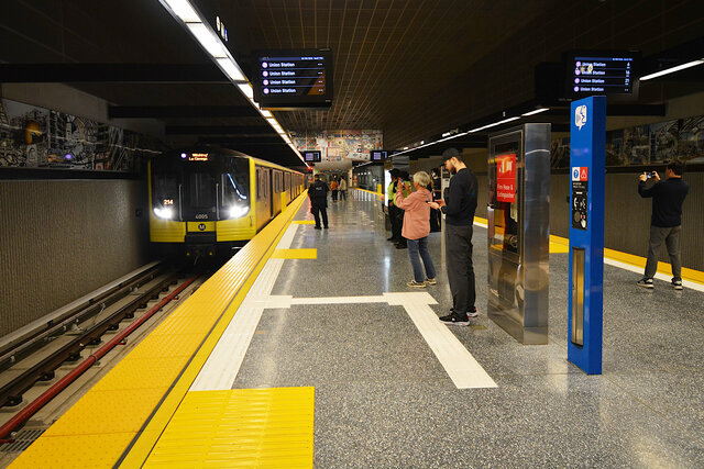 Passengers photograph the train arriving at Wilshire/La Cienega
