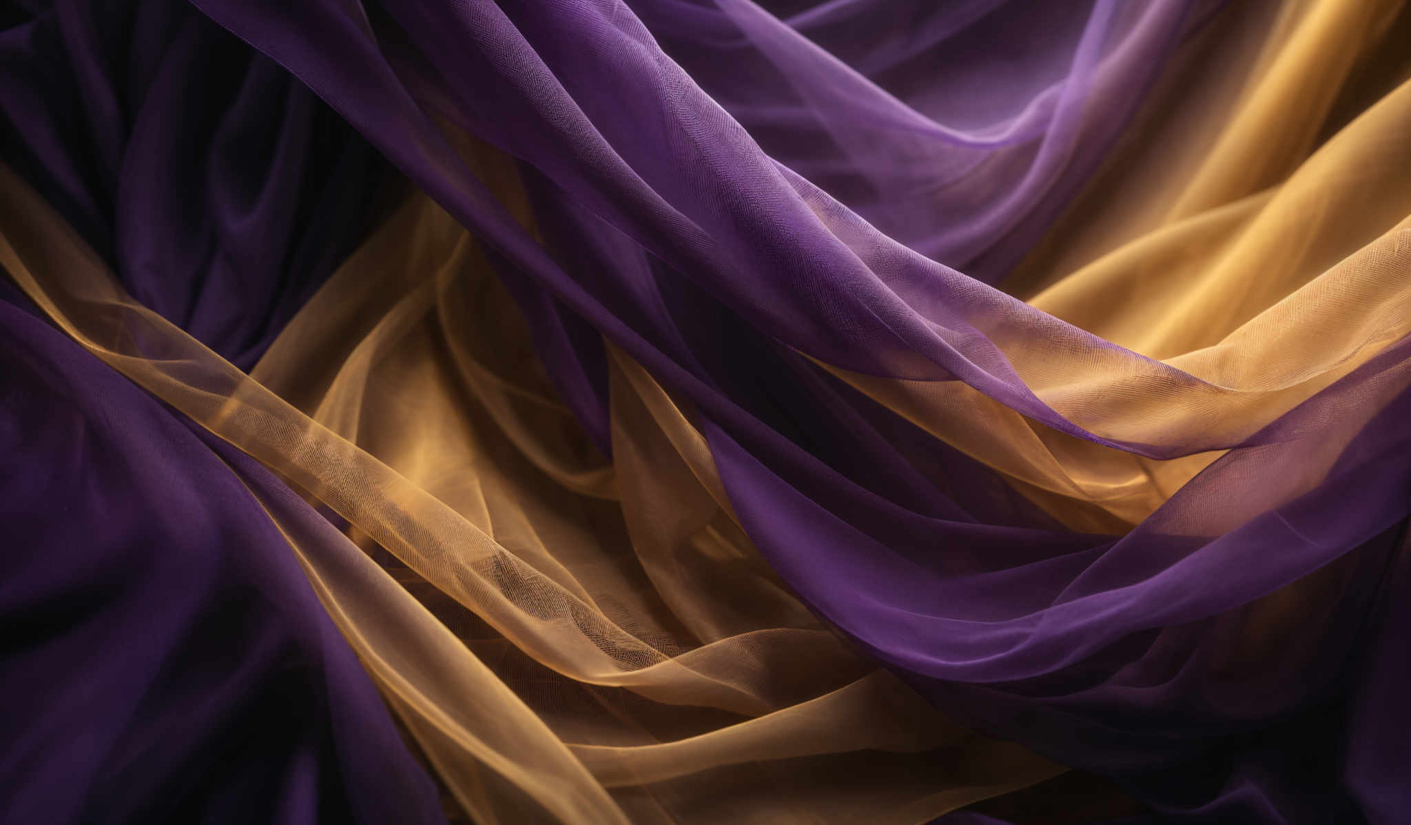 The image showcases a beautiful interplay of colors and shapes. It features flowing, translucent fabric in shades of purple and gold. The fabric appears to be draped and folded in intricate patterns, creating a sense of movement and depth. The gold fabric has a slightly lighter hue, contrasting with the deeper purple shades, which adds to the visual appeal. The overlapping and intertwining of the fabrics create a complex and layered texture, making the image appear dynamic and ethereal.