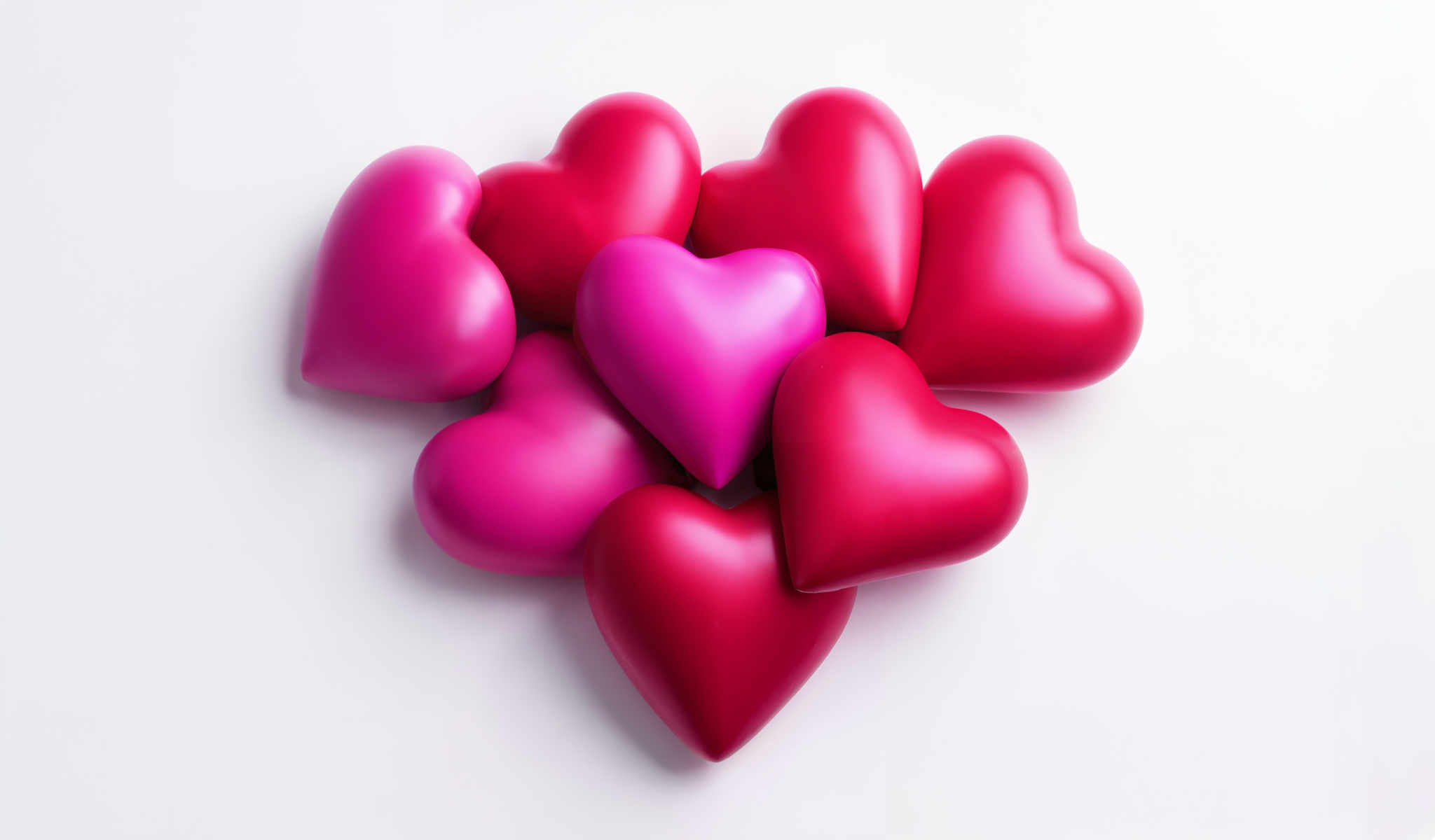 A collection of 16 heart shaped objects all in a vibrant shade of pink. They are arranged in a circular pattern with each heart touching its neighbors creating a sense of unity and love. The hearts are evenly spaced maintaining a consistent distance from each other which adds to the symmetry of the arrangement. The background is a stark white which contrasts with the pink hearts and makes them stand out. The image does not contain any text or other discernible objects. The focus is solely on the pink heart shaped figures and their arrangement.