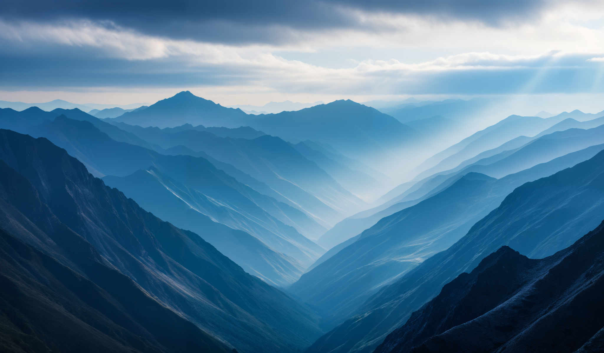 A breathtaking view of a mountain range with a blue sky and clouds. The mountains are covered in a lush green vegetation. The sky is a beautiful shade of blue with white clouds scattered throughout. The sun is shining brightly casting a warm glow on the mountains. The image captures the majesty and beauty of nature in its purest form.