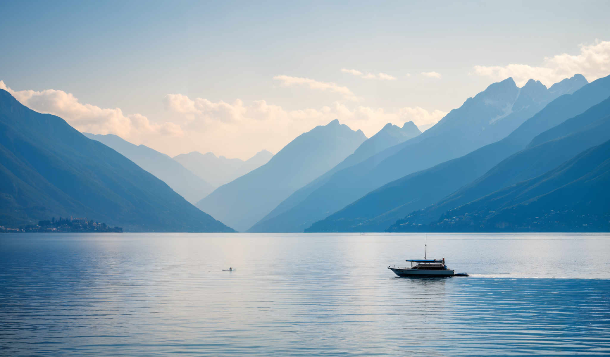 A boat is sailing on a body of water in front of a mountain range.