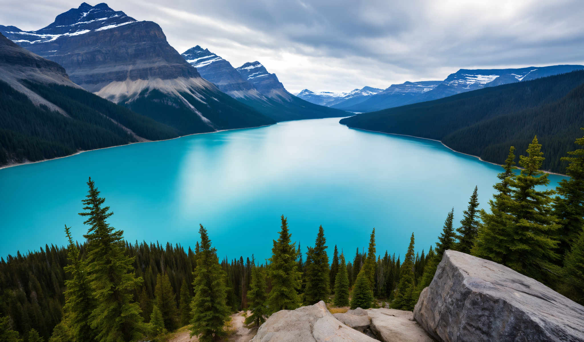 A serene mountainous landscape with a beautiful turquoise lake in the center. The lake is surrounded by mountains and is nestled in a valley. The mountains are covered in a lush blanket of green trees. The sky above is a clear blue with a few clouds scattered across it. The image is taken from a high vantage point providing a panoramic view of the lake and the surrounding mountains. The colors in the image are vibrant and the lighting is natural highlighting the beauty of the landscape. The overall scene is peaceful and tranquil inviting viewers to appreciate the beauty and majesty of nature.