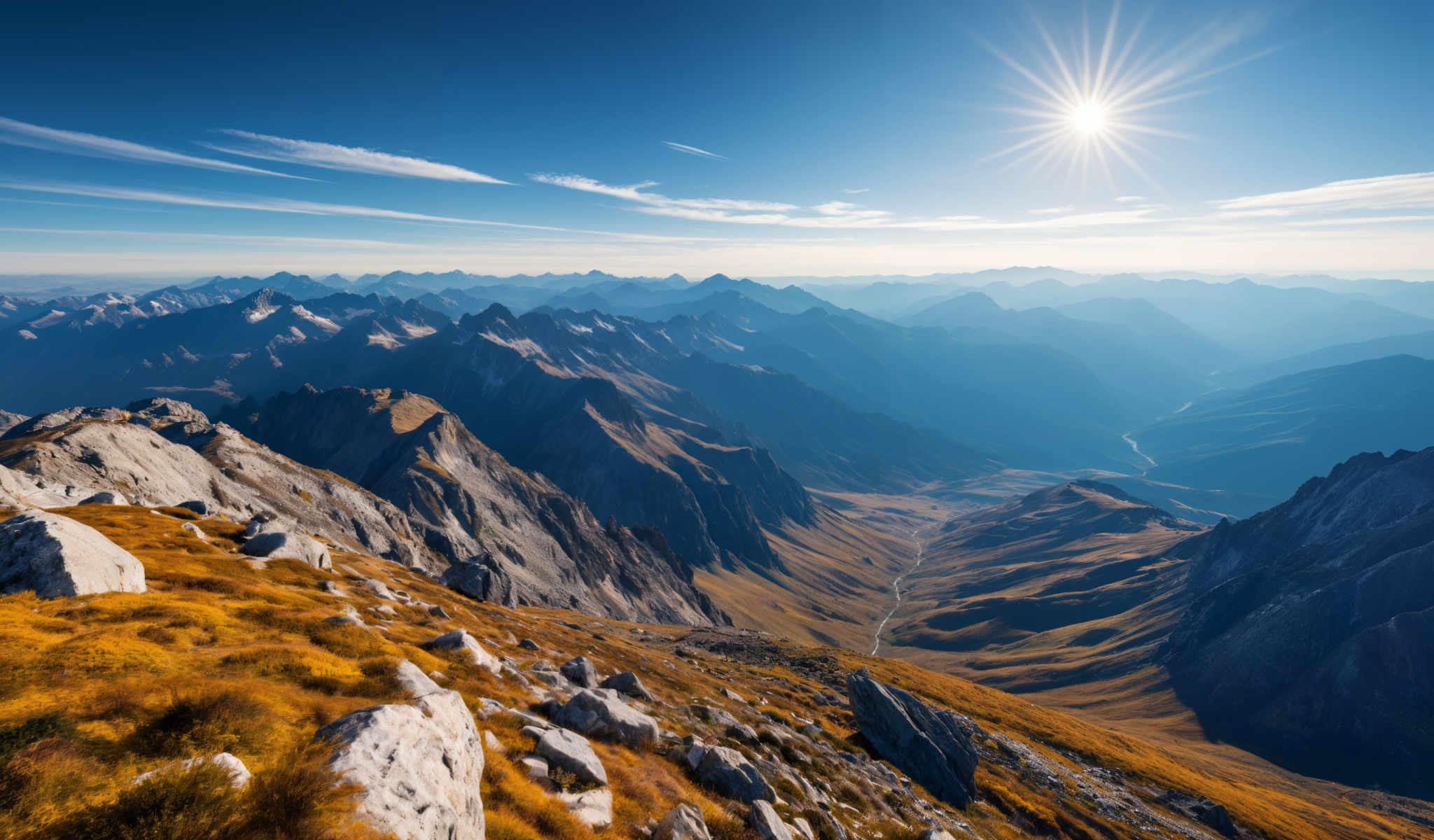 A breathtaking view of a mountain range with a river flowing through it. The mountains are covered in a lush green vegetation and the sky is a clear blue with a few clouds scattered across it. A bright sun is shining in the top right corner of the photo casting a warm glow over the entire scene. The photo is taken from a high vantage point giving a panoramic view of the landscape below. The river winds its way through the mountains creating a beautiful contrast with the greenery. The image captures the serene beauty of nature in its raw form.