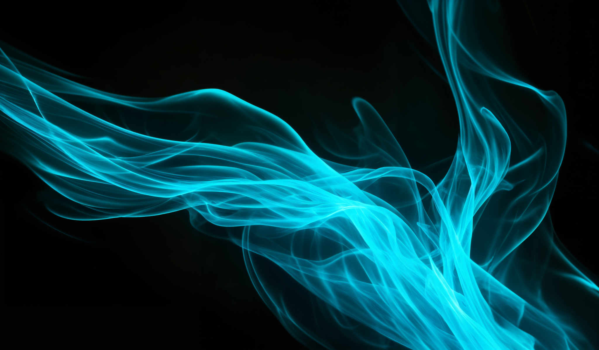 The image showcases a vibrant blue smoke or mist against a dark background. The smoke takes on intricate, fluid shapes, resembling ethereal tendrils or wisps. The blue hue is intense and gives the smoke a mystical and otherworldly appearance. The swirling patterns and the contrast between the bright blue and the deep black create a visually captivating scene.